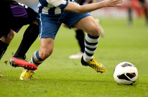 Man evades tacles playing football (soccer)